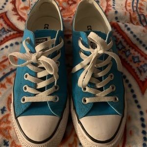 Turquoise converse shoes.